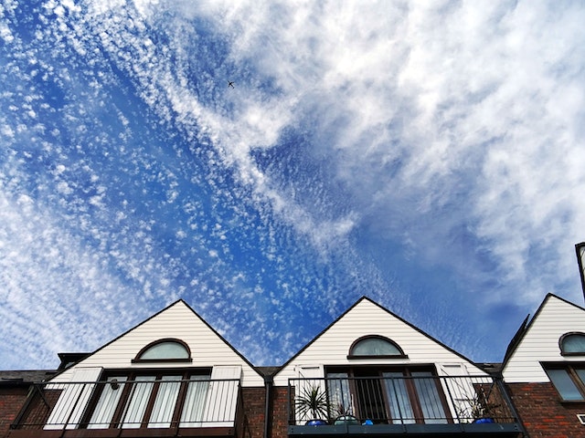 Exterior of three houses against a blue sky